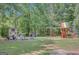 A wonderland, featuring a playset, playhouse, and seating, all set in a spacious, tree-lined yard at 305 Sherwood Rd, Fayetteville, GA 30215