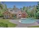 Gorgeous in-ground pool with patio, surrounded by a lush green yard and stately brick home, perfect for relaxing and entertaining at 305 Sherwood Rd, Fayetteville, GA 30215