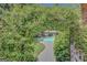 Serene view of the backyard pool area, framed by a lush, green archway and featuring meticulously kept grounds at 305 Sherwood Rd, Fayetteville, GA 30215