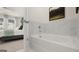 Bright bathroom featuring a tub, marble tile, and view into the main bedroom at 566 Silver Moon Dr, Loganville, GA 30052