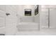 Bright bathroom featuring a tub and glass door shower with white marble tile at 566 Silver Moon Dr, Loganville, GA 30052