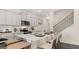 An eat-in kitchen features shaker cabinets, stainless appliances, a breakfast bar, and a view of the home's staircase at 566 Silver Moon Dr, Loganville, GA 30052