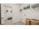 Functional laundry room with shelving, ample storage baskets, and access to additional room at 566 Silver Moon Dr, Loganville, GA 30052