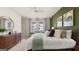 Bright main bedroom showcasing a neutral color scheme, green accent wall, and elegant furniture at 566 Silver Moon Dr, Loganville, GA 30052