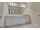 This bathroom features a double sink vanity with a large mirror, and neutral tiled floors at 115 Robinwood Ct, Fayetteville, GA 30214