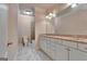 This bright bathroom features a double sink vanity with a large mirror, and white marble floors at 115 Robinwood Ct, Fayetteville, GA 30214