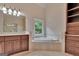 Bathroom featuring a double sink vanity, soaking tub, and natural light at 115 Robinwood Ct, Fayetteville, GA 30214