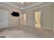 This bedroom features neutral carpeting, a television, and multiple doorways at 115 Robinwood Ct, Fayetteville, GA 30214