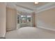 This bedroom features neutral carpeting, tray ceilings, and large windows with views of a neighbor's house at 115 Robinwood Ct, Fayetteville, GA 30214