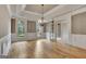 Bright dining room with hardwood floors, an ornate chandelier, and arched windows at 115 Robinwood Ct, Fayetteville, GA 30214