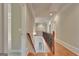 Hallway leading to bedrooms featuring hardwood floors, neutral paint, decorative railing, and recessed lighting at 115 Robinwood Ct, Fayetteville, GA 30214