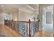 This beautiful hallway features hardwood floors, wrought iron railings, and a gorgeous chandelier at 115 Robinwood Ct, Fayetteville, GA 30214