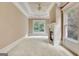 Sunlit main bedroom with decorative tray ceiling, a fireplace, carpeted floors, and bright windows at 115 Robinwood Ct, Fayetteville, GA 30214
