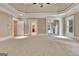 Large carpeted main bedroom featuring decorative ceiling, windows, and access to ensuite bathroom and walk-in closet at 115 Robinwood Ct, Fayetteville, GA 30214