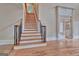 Staircase with hardwood steps, decorative metal railings, and views into other rooms with glass-paned doors at 115 Robinwood Ct, Fayetteville, GA 30214