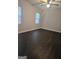 Spacious bedroom featuring dark wood flooring, two windows, and a ceiling fan at 5425 Herndon Blvd, Morrow, GA 30260