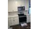Kitchen with white cabinets and countertops, featuring stainless steel microwave and stove at 5425 Herndon Blvd, Morrow, GA 30260