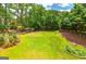 Large backyard with green grass, surrounding trees, and a wooden fence, great for outdoor activities at 1120 Bagwell Dr, Kennesaw, GA 30152