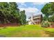 View of the spacious backyard, with lush lawn, mature trees, and charming wooden fence at 1120 Bagwell Dr, Kennesaw, GA 30152