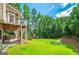 Expansive backyard with lush lawn and deck for outdoor entertaining surrounded by mature trees and a wood fence at 1120 Bagwell Dr, Kennesaw, GA 30152