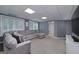 Spacious finished basement with gray walls, a plush sectional sofa, and large windows at 1120 Bagwell Dr, Kennesaw, GA 30152