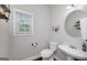 Charming powder room with hardwood floors, a pedestal sink, and natural light from the window at 1120 Bagwell Dr, Kennesaw, GA 30152