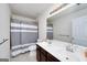 Bright bathroom with a double sink vanity, large mirror, tile flooring, and a shower with a gray curtain at 1120 Bagwell Dr, Kennesaw, GA 30152