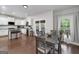 Dining area adjacent to the kitchen features hardwood floors, gray table and chairs, and backyard access at 1120 Bagwell Dr, Kennesaw, GA 30152