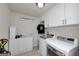 Clean laundry room with white cabinets, modern washer and dryer, and tiled flooring at 1120 Bagwell Dr, Kennesaw, GA 30152