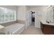 Main bathroom featuring a soaking tub, a closet and a wood vanity at 1120 Bagwell Dr, Kennesaw, GA 30152