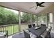 Covered screened-in porch with a ceiling fan features outdoor seating and views of the wooded backyard at 1120 Bagwell Dr, Kennesaw, GA 30152