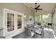 Covered and screened-in porch with outdoor seating, ceiling fan, and views of the wooded backyard at 1120 Bagwell Dr, Kennesaw, GA 30152