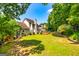 Expansive green backyard featuring the home's exterior, a deck, and lush, mature trees providing shade and privacy at 306 Sandalin Ln, Peachtree City, GA 30269