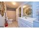 Well-lit bathroom with a starburst mirror and a shower with a curtain at 306 Sandalin Ln, Peachtree City, GA 30269