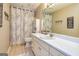 Well-lit bathroom featuring a wide vanity, neutral walls, and a shower with patterned curtain at 306 Sandalin Ln, Peachtree City, GA 30269