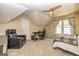 Upstairs bedroom area with dormered ceiling, gaming chair, and comfortable bed under ceiling fan at 306 Sandalin Ln, Peachtree City, GA 30269