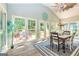 View of the sunny dining area with back yard views through large windows and glass doors at 306 Sandalin Ln, Peachtree City, GA 30269