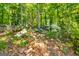 View of natural landscaping with mature trees, rocks and a wooden fence defining the edge of the property at 306 Sandalin Ln, Peachtree City, GA 30269