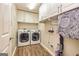 Functional laundry room with white cabinets, washer, and dryer on stylish wood look flooring at 306 Sandalin Ln, Peachtree City, GA 30269