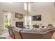 Elegant living room with a fireplace, high ceilings, and a comfortable leather sectional sofa at 306 Sandalin Ln, Peachtree City, GA 30269
