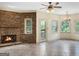 Open living room with brick fireplace, tile floors, and a glass door to the patio at 232 Darwish Dr, Mcdonough, GA 30252