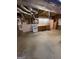 This unfinished basement has cement floors and exposed ceiling, and a kitchenette area with wood cabinets at 2142 E Atlanta Rd, Stockbridge, GA 30281