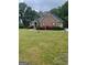 Well-maintained brick home with a spacious front yard and blooming shrubs at 2142 E Atlanta Rd, Stockbridge, GA 30281