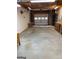 Spacious garage with roll-up door, concrete floor, and shelving for storage at 2142 E Atlanta Rd, Stockbridge, GA 30281