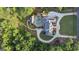 A beautiful aerial view of a luxury home with a pool surrounded by lush landscaping and mature trees at 1385 Gordon Rd, Moreland, GA 30259