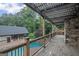 Wooden deck with string lights overlooking a pool, pool house, and landscaped backyard at 1385 Gordon Rd, Moreland, GA 30259