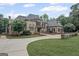 Beautiful brick home featuring a circular driveway, mature landscaping, and stone accents at 1385 Gordon Rd, Moreland, GA 30259