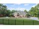 Elegant brick home with a manicured lawn, mature landscaping, and gated entrance at 1385 Gordon Rd, Moreland, GA 30259