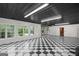 Spacious garage featuring a black and white checkered floor, bright lighting, and large windows at 1385 Gordon Rd, Moreland, GA 30259