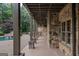 Covered patio features stone accents, a pool view, and access to a lushly landscaped backyard at 1385 Gordon Rd, Moreland, GA 30259